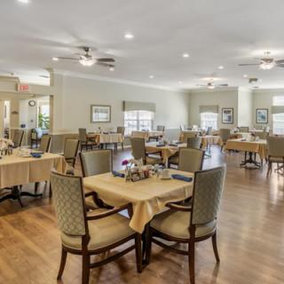 A spacious and elegantly decorated dining room with neatly arranged tables and chairs.