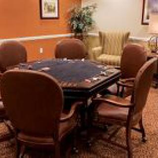 A cozy indoor game room featuring a poker table surrounded by comfortable chairs.