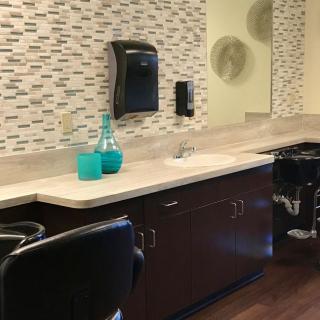 A modern barber shop interior with chairs and a countertop featuring decorative elements.