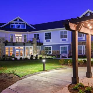 A well-lit building exterior with landscaped surroundings and a pathway at night.