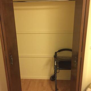 An empty closet with a walker stored inside.