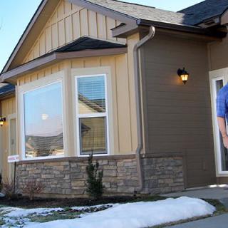 A residential house with snow on the ground in front.