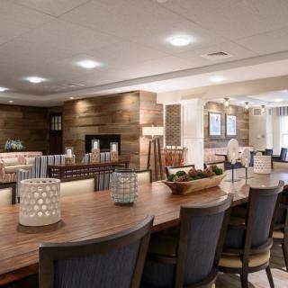A modern dining area featuring a large wooden table, comfortable chairs, and stylish lighting.
