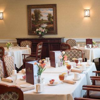 A cozy restaurant dining room with elegantly set tables and classic decor.