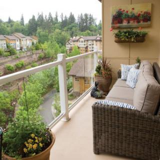A cozy balcony adorned with plants and comfortable seating, offering a serene view of the lush landscape.