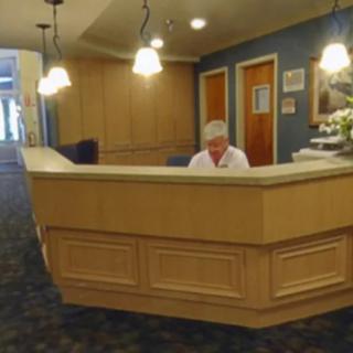 A person working at a reception desk in an office interior.