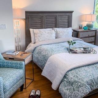 A cozy bedroom with stylish decor and a neatly made bed.