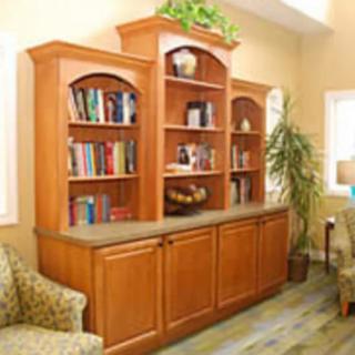 A wooden bookshelf in a living room with books and decorative items.