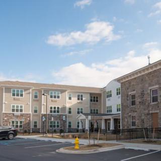 A modern residential apartment complex under a cloudy sky.