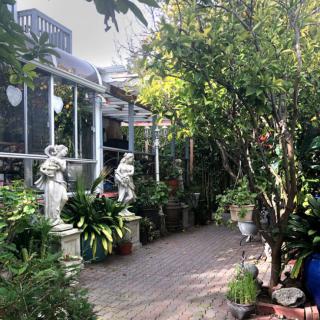 A tranquil garden path lined with statues and lush greenery.