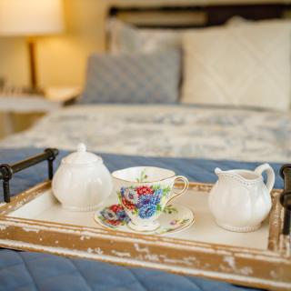 A cozy tea set on a tray in a comfortable bedroom setting.