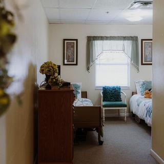 A cozy bedroom with two beds, a window, and simple decor.