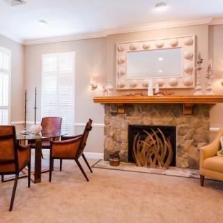 A cozy living room with a stone fireplace, dining table, and elegant decor.