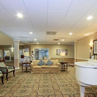 A cozy and elegantly furnished lobby with seating area and a piano.