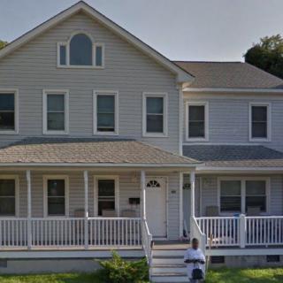 A two-story suburban house with a front porch and multiple windows.