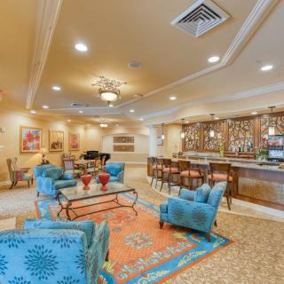 A spacious lobby with elegant furniture and a bar area.
