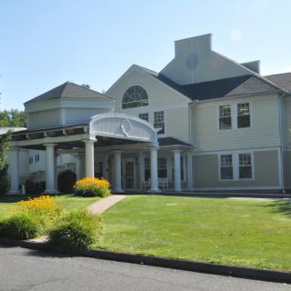 A large residential building with a well-maintained lawn and garden.