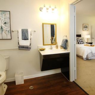 A modern bathroom with a view into an adjacent bedroom.