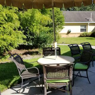 Outdoor patio area with a table, chairs, and umbrella on a sunny day.