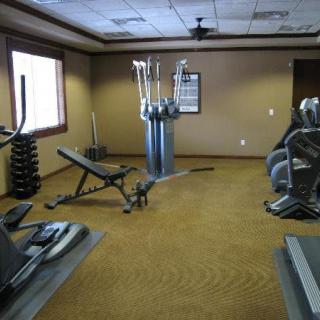 A well-equipped gym with various exercise machines and weights.