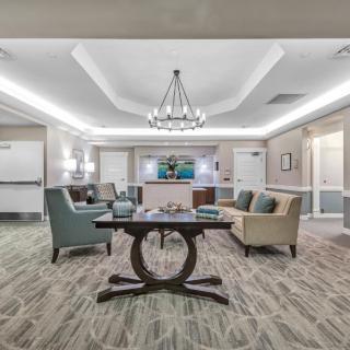 A modern lobby with comfortable seating and a chandelier centerpiece.
