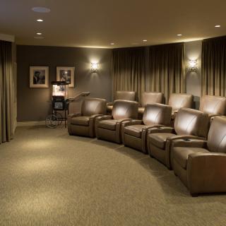 A cozy home theater with leather recliners and ambient lighting.