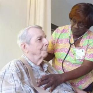 A healthcare worker performing a checkup on an elderly patient.