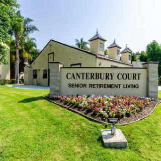 Entrance sign of Canterbury Court, a senior retirement living community, surrounded by landscaped gardens.