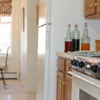 A cozy kitchen featuring a stove and decorative bottles on the counter.