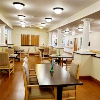 A well-lit dining area with neatly arranged tables and chairs.