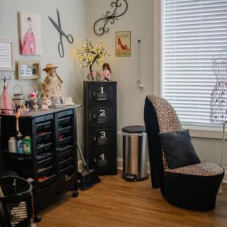 A cozy and well-decorated salon interior with styling chairs and organized beauty products.