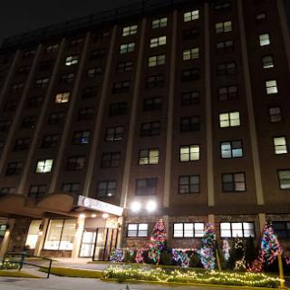 A nighttime view of a residential building adorned with festive lights.