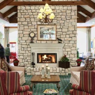 A cozy living room with a stone fireplace and comfortable seating.
