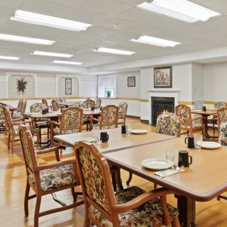 An empty dining room with neatly arranged tables and chairs, ready for guests.