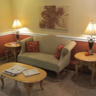 A cozy living room with a sofa, tables, and decorative lamps.