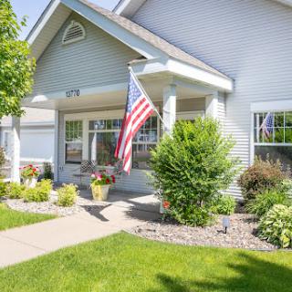 A welcoming home with a well-maintained front yard and an American flag proudly displayed.