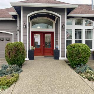A welcoming entrance to a beautifully designed home with manicured landscaping.