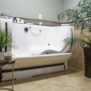 A modern bathroom featuring a walk-in bathtub surrounded by indoor plants.