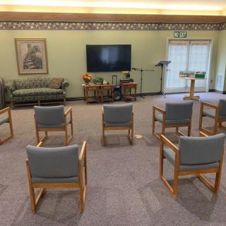 A seating area with arranged chairs facing a television.