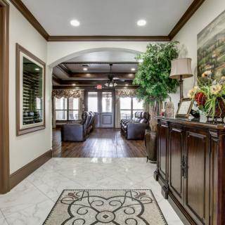 A beautifully decorated foyer with elegant furniture and ornamental plants.