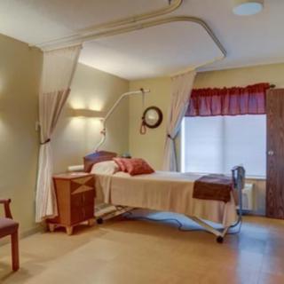 A hospital room with a bed and medical equipment.