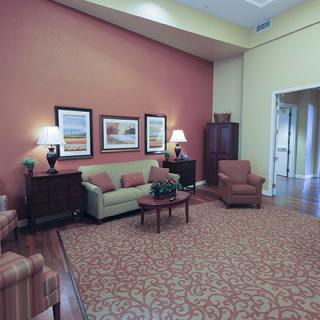 A cozy living room with a sofa, armchairs, and decorative artwork.