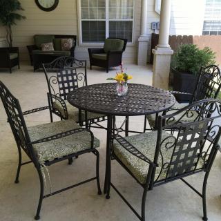 A cozy patio setup featuring an iron table and chairs, perfect for outdoor seating.
