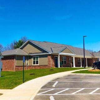 A healthcare clinic with a parking lot under a clear blue sky.