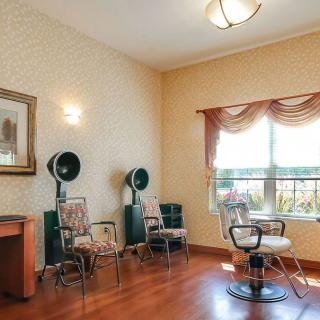 A cozy hair salon room with vintage dryer chairs and warm decor.