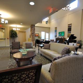 A spacious and well-furnished living room with comfortable seating and a grand piano.
