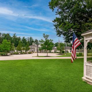 A scenic view of a gazebo with an American flag in a park setting.