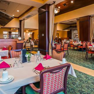 An elegant restaurant dining area with neatly arranged tables and chairs, set for guests.