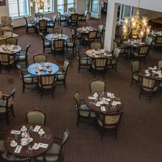 An elegant restaurant dining room with neatly arranged tables and chairs.