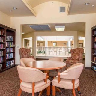 A cozy library reading area with bookshelves and comfortable seating.